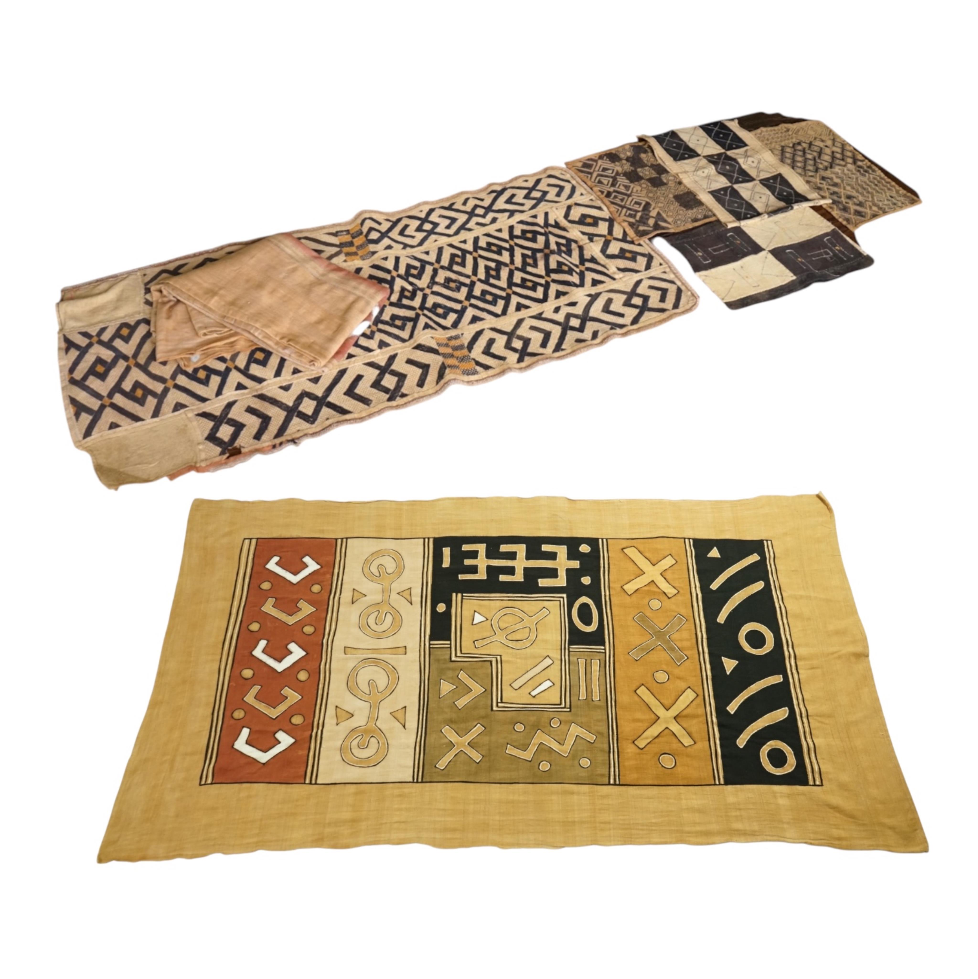 A collection of five 20th century African Congo hand woven and embroidered raffia palm leaf runners and mats, together with a later large printed hanging. 260cm x 138cm. Condition - one smaller mat has a hole in the weav
